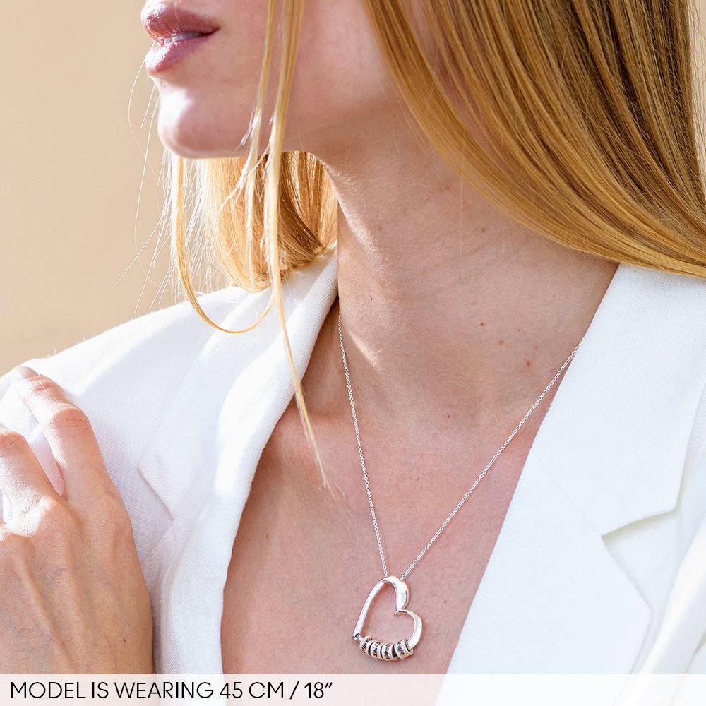 Charmerende hjertehalskæde med ingraverede charms i sølv produkt billede